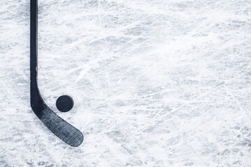 Black hockey stick and rubber puck on ice background. Closeup. Empty place for text. Top down view. - obrazy, fototapety, plakaty