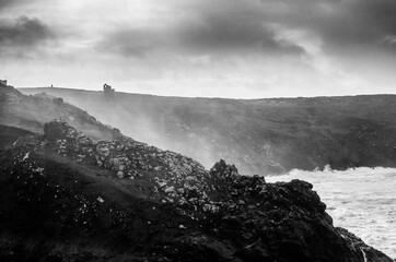 Moody Coastal Scene, Sea Spray Rising over jagged Cliffs and Ruined Mines in Black and White