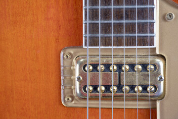 Close up view of the strings and a pickup of a guitar