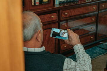 grandfather or senior talking on video call with mobile phone