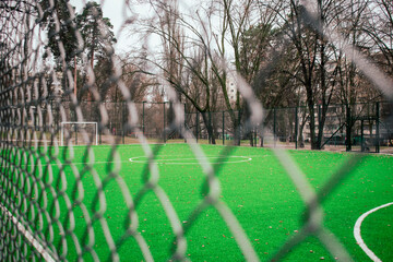 Empty soccer field behind a metal fence