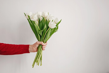 Man holding a bouquet of fresh spring flowers.