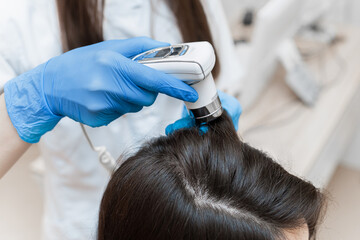 Trichoscopy of a woman's head with a trichoscope close up