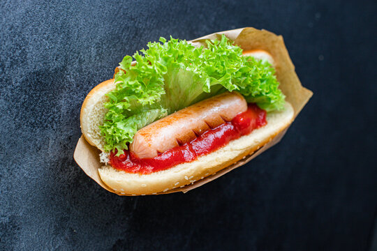 Hot Dog sandwich fast foodsausage tomato sauce lettuce leaf  portion meal snack top view copy space for text food background rustic image