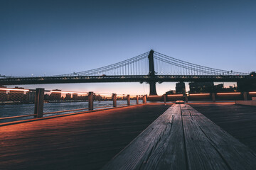 Fototapeta na wymiar bridge manhattan new york city seat wood panorama pier sunrise sky lights horizon buildings 