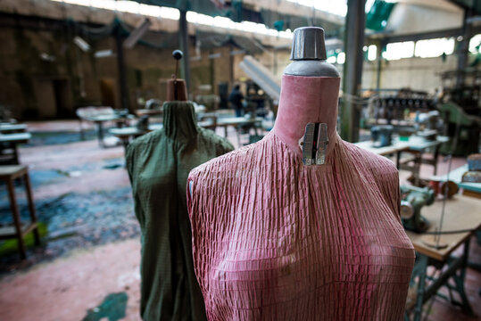 Close up of a pink and green faded tailor's dummies in an old and abandoned Italian textile factory