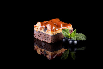 Sweet chocolate and nut dessert on a black background. Mirror reflection.