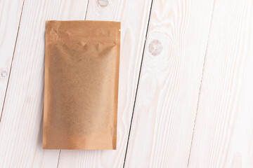 Paper package with seeds. Top view. On a white wooden background.