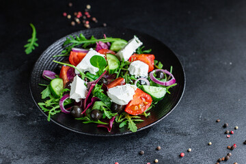 Greek salad mix vegetable tomato, cucumber, olives lettuce greens vitamin portion on the table healthy snack top view copy space food background rustic image