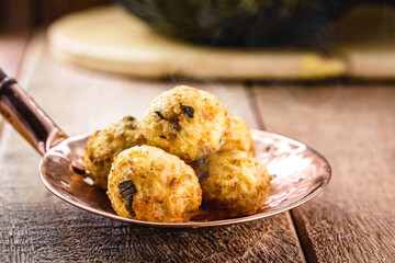 cod dumplings, fish meat dumpling in a slotted spoon, fried salty