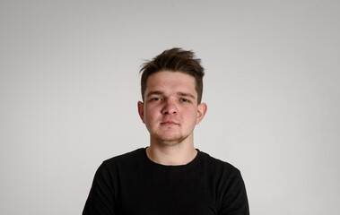 
teen guy looking at camera
seriously thinking about matters concerned on a white background in a black T-shirt