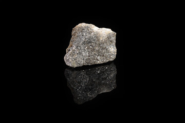 Natural mineral rock specimen - raw Arsenopyrite stone on black glass background from Kachkarskoe, Ural, Russia.