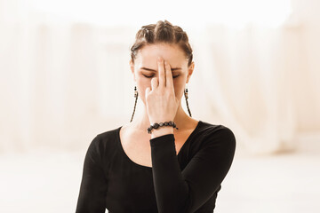 Close-up portrait of a woman practicing yoga, showing the symbol of jnana mudra on her face while breathing pranayama Nadi shodhana