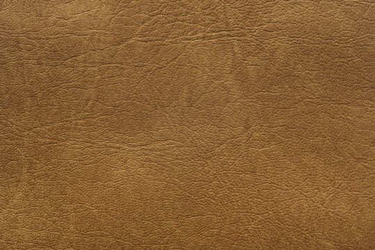 Brown leather texture with light streaks, background.