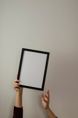 hands holding black frame with white background