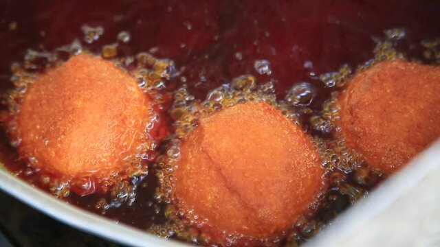 salvador, bahia, brazil - february 15, 2021: baiana fries the acaraje in palm oil on a tray in the street of downtown Salvador.
