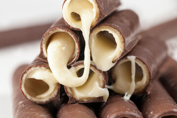 milk filling flows out of waffle tubes in chocolate