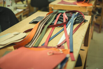 stack of colored leather parts, work in a bag factory, processing leather parts for bags, work in a factory, the process of creating accessories