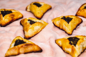 Purim holiday celebration. Hamantaschen cookies on pink background. Top view