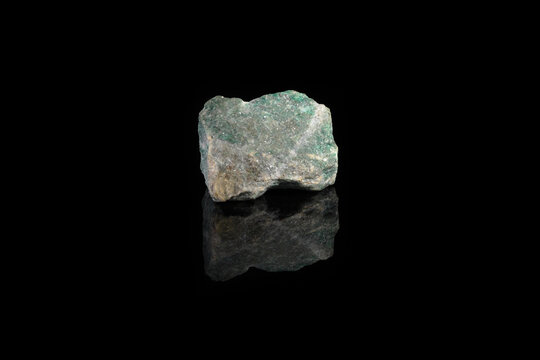 Natural rock specimens - green listvenite, listwanite mineral from Berezovsk, Ural, Russia on black glass background.