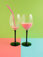 Cold and fresh pink drink for summer party on green, pink and blue background