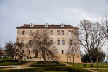 Renaissance castle with Sgraffito decorated facade, chateau with park, footpath in garden on sunny winter day, Benatky nad Jizerou, Central Bohemian, Czech Republic