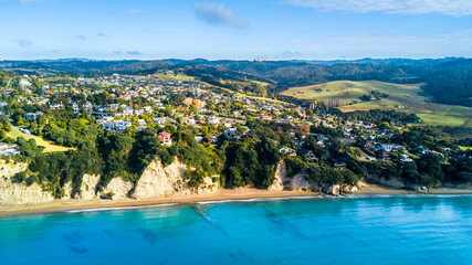 Aerial view of a beautiful suburb on the shore of a quiet harbour on a sunny morning. Auckland, New Zealand
