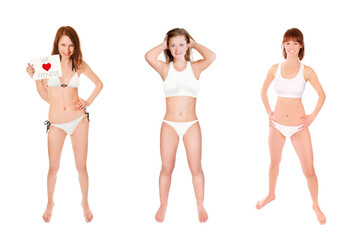 Full length portraits of three beautiful young women wearing white bikinis, one is holding a placard, we love fitness is written on the paper, isolated on white studio background