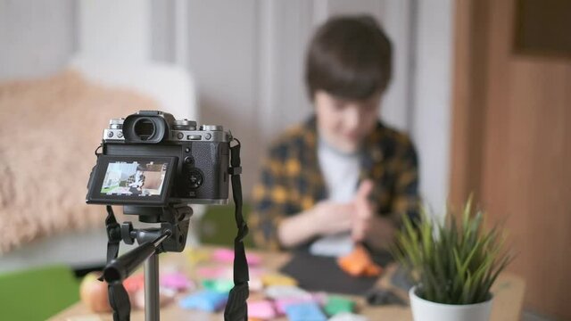 The boy is a vlogger. The boy is recording a vlog for his YouTube channel. 