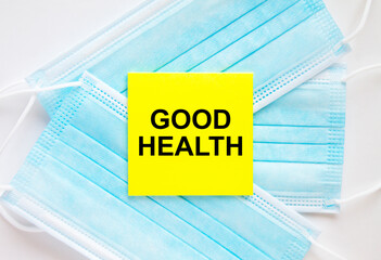 Yellow sticker with text Good Health lying on the masks