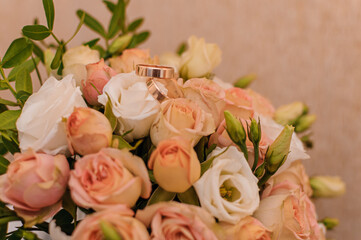 Bridal bouquet with orange roses. Gold wedding rings