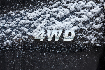 an abbreviation 4wd - Four-wheel drive - on dirty black car back