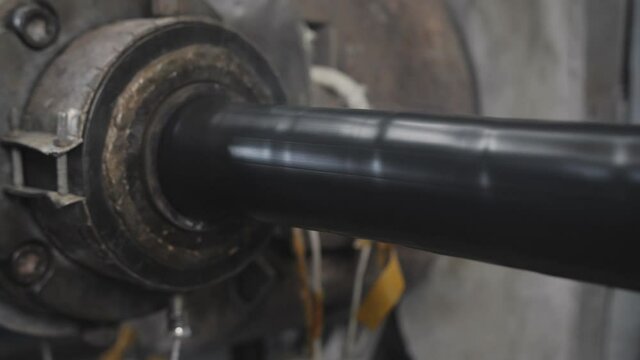 Applying a heat shrink layer to a thick power shielded cable on a production line in a factory.