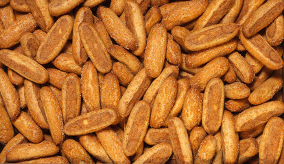 Breadsticks, cookie sticks, sprinkled with sugar for background. Top view.