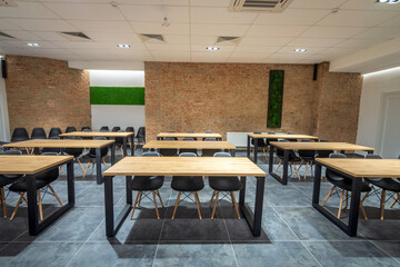  Interior of an empty classroom conference hall with black chairs,  flipcharts and white screen.