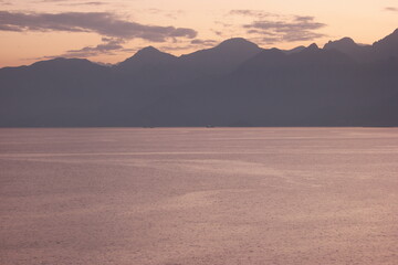Beautiful evening seascape with mountains in the background. Background of sea and mountains at sunset time.
