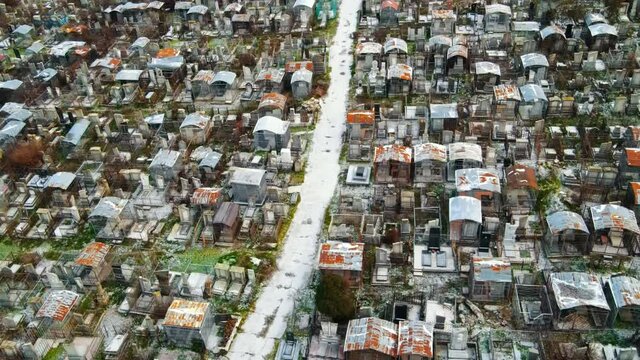 Aerial drone view of a cemetery in Chisinau, Moldova. Multiple graves, crypts, walkway, Cloudy weather, bare trees, winter