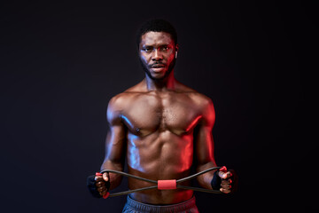 Fototapeta na wymiar muscular man training with sport equipment, pumping arm muscles biceps. isolated on black background