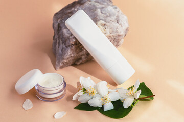 Beauty spa medical skincare and cosmetic lotion cream serum oil mockup bottle with jasmine blossom. Natural stone decor