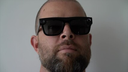 Bearded man wearing futuristic video recording sunglasses