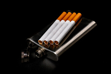 Metal flask and cigarettes. Metal container for alcohol and smoking tobacco.