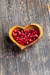fresh pomegranate seeds in a heart-shaped bowl