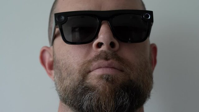 Bearded man wearing futuristic video recording sunglasses