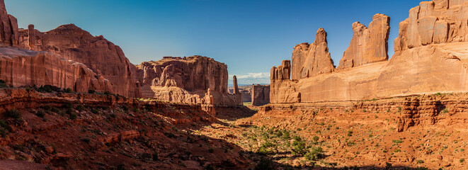 Panorama shot of red sandstone rocks, monoliths and mountains in Park Avenue in arches national park in utah, america