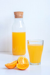 Orange juice in a glass and fruits on white background, close up