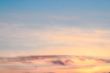 Sunset theme for sky replacement background with pink, orange, pastel clouds, blue sky and sun shining on the horizon. Great for tranquil, calm, serene country or rural themed art.