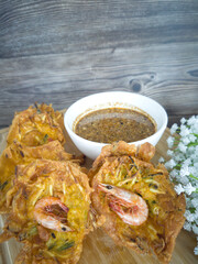 Fried prawn fritters or commonly known as cucur udang served with spicy peanut sauce. Selective focus points. Blurred background