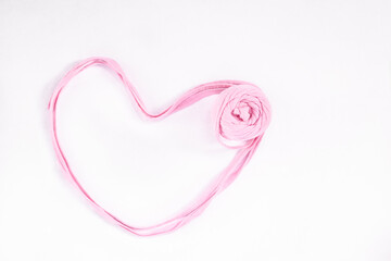 Pink handmade heart closeup. Romantic concept. Ribbon yarn knitting craft banner.