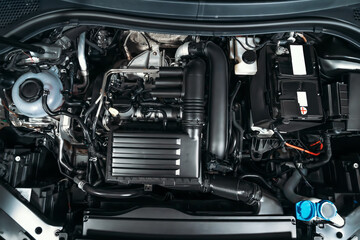 Fototapeta na wymiar View under car hood at modern turbocharged eco-friendly engine or motor close up.