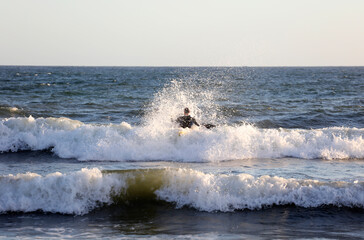 athlete with canoe, among the waves of the sea